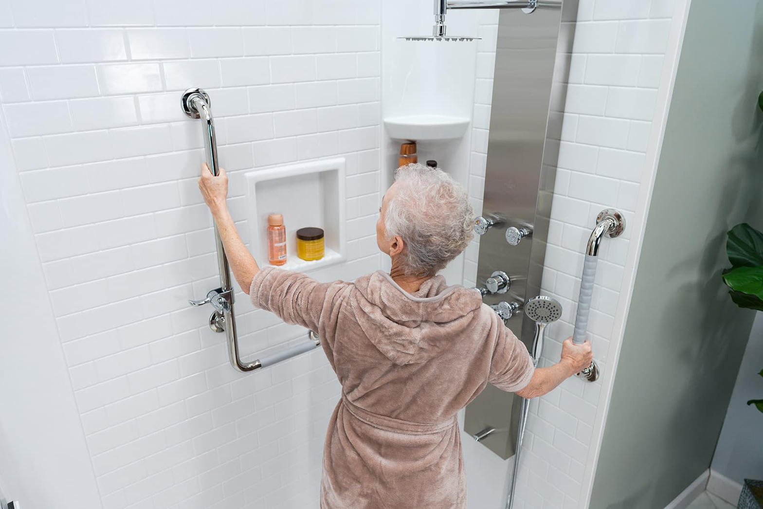 Senior using stainless steel grab bars in a safe accessible shower